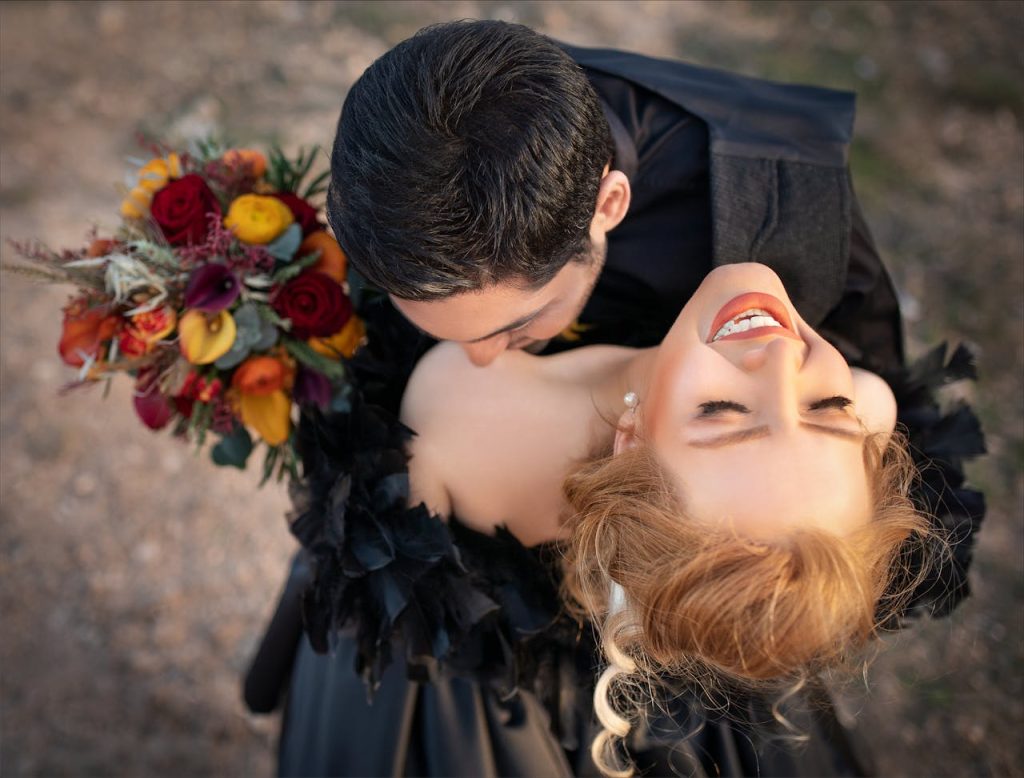 pexels-photo-2649227 A joyous couple embracing outdoors, holding a vibrant flower bouquet.